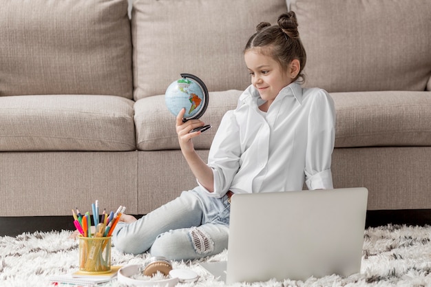 Free Photo little girl looking at an earth globe