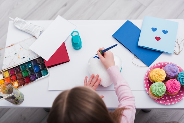 Little girl painting a heart