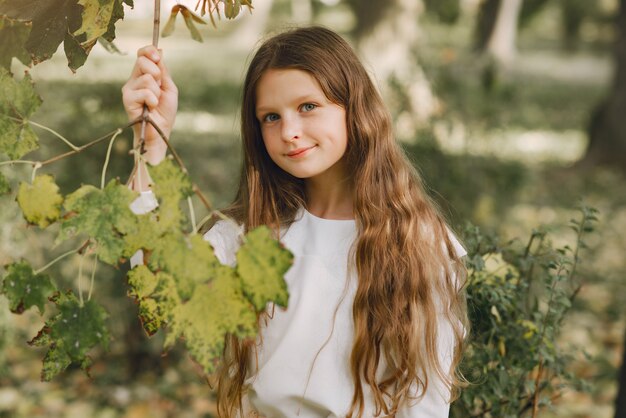 Little girl in a park in a white blouse