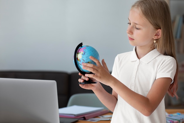 Free photo little girl playing with an earth globe