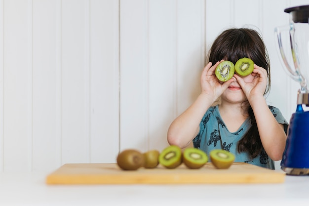 Little girl posing with kiwifruit