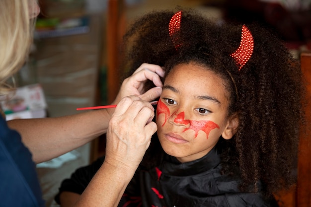 Little girl preparing for halloween with a devil costume