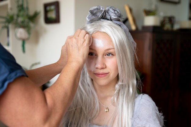 Little girl preparing for halloween with a ghost costume