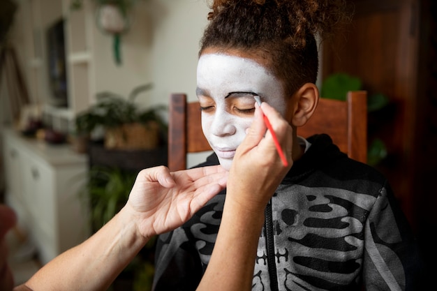 Free Photo little girl preparing for halloween with a skeleton costume