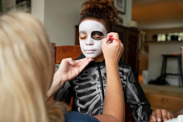 Little girl preparing for halloween with a skeleton costume