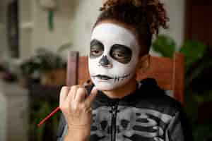 Free photo little girl preparing for halloween with a skeleton costume