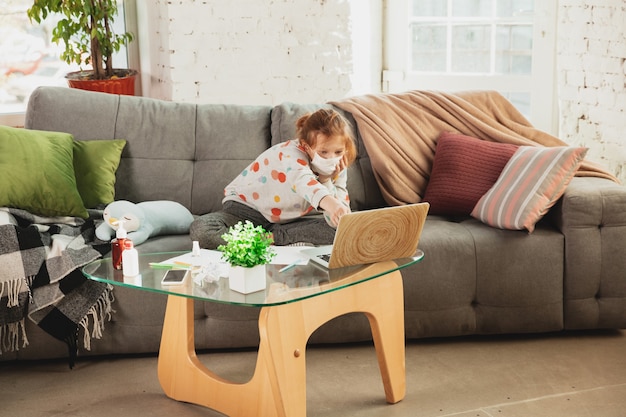 Little girl in protective mask isolated at home