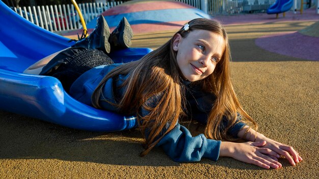 Little girl staying on the edge of a slide