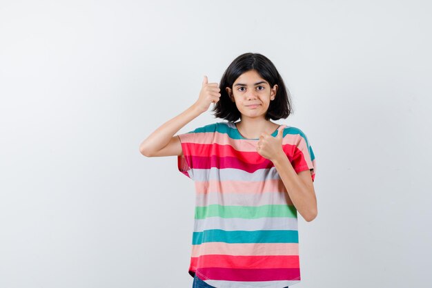 Little girl in t-shirt showing double thumbs up and looking happy , front view.