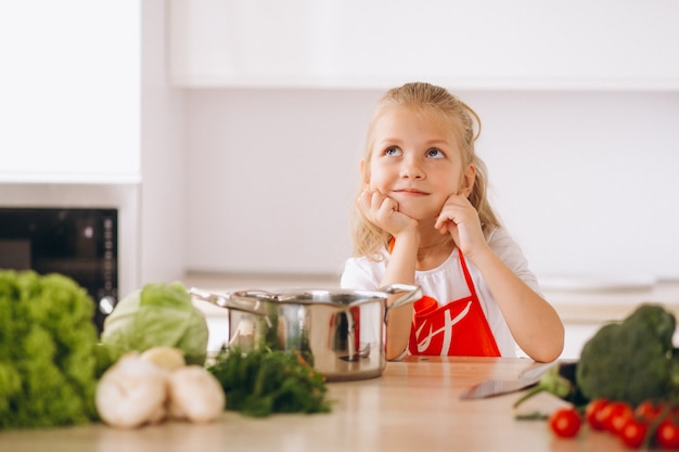 Little girl thinking what to cook at the kitchen