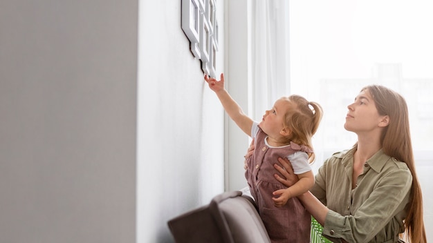 Little girl touching frame on the wall