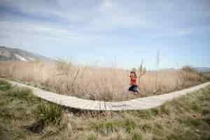 Free photo little girl walking on a path of wooden boards in a wetland in padul, granada, andalusia, spain