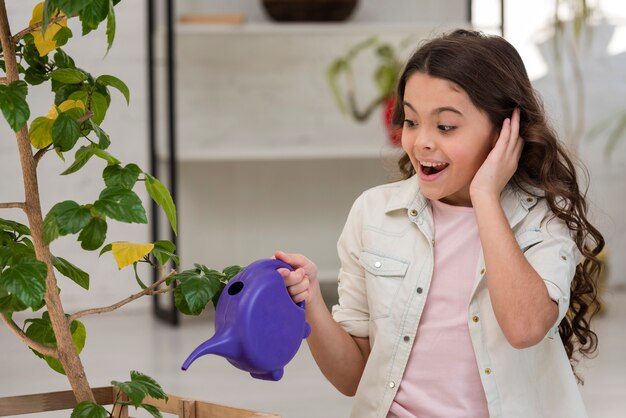 Little girl watering the plant