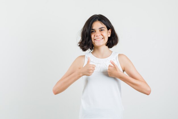 Little girl in white blouse showing double thumbs up and looking cheerful , front view.