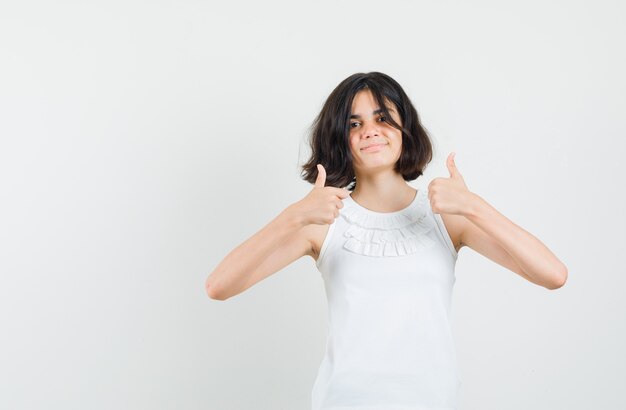 Little girl in white blouse showing double thumbs up and looking pleased , front view.