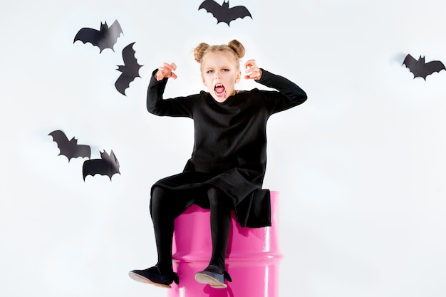 Free Photo little girl witch in black long dress and magical accessories.