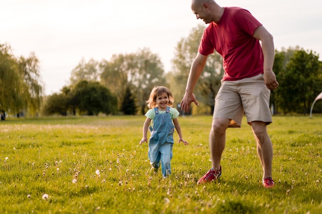 Free Photo little girl with dad. dad throws baby up in the air. cheerful laughter, emotional child, happiness.