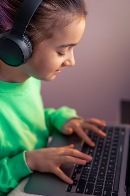 Little girl with laptop plays games concept of game addiction