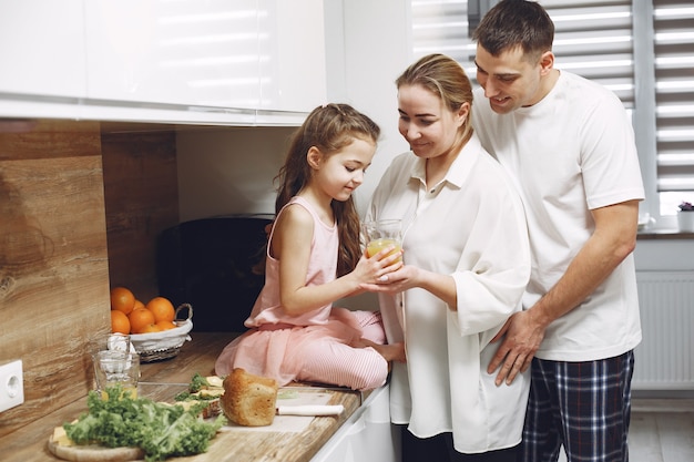 Little girl with long hair. Father, mother and daughter together. Family prepares to eat.