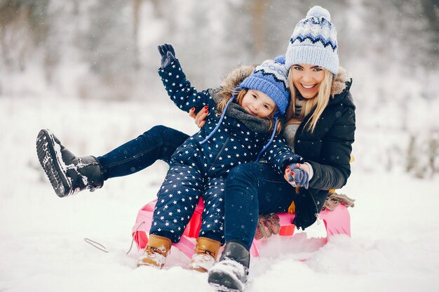 Little girl with mother playing in a winter park