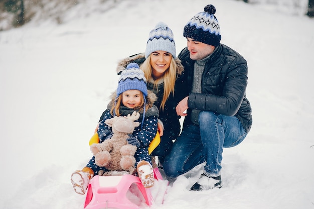 Little girl with parents playing in a winter park