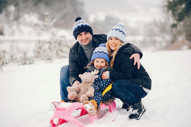 Little girl with parents playing in a winter park