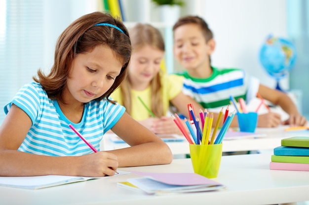 Little girl writing something in her notebook