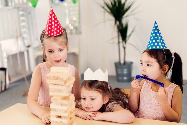 Little girls in colored caps playing