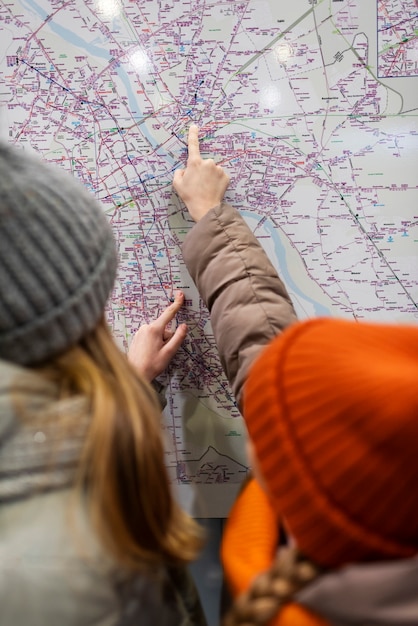 Free photo little girls consulting a map on their familiar trip