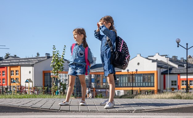 Little girls, elementary school students after school, on their way home.