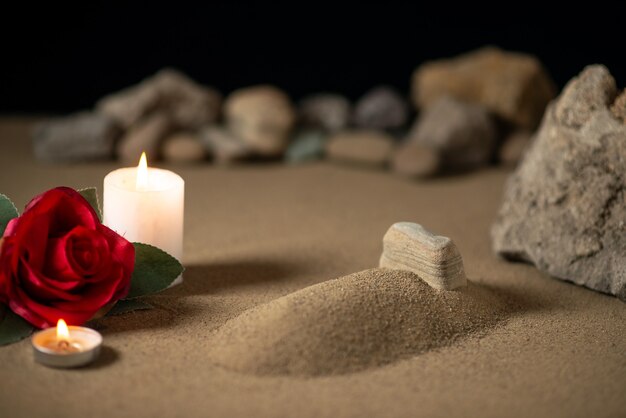 Little grave with candle and stones on sand funeral war moon