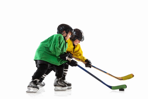 Little hockey players with the sticks on ice court and white  background.