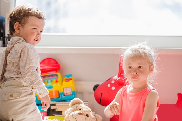 Little kids posing at window