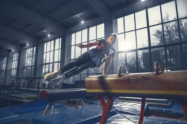 Little male gymnast training in gym flexible and active