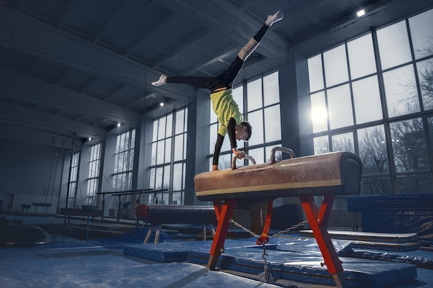 Little male gymnast training in gym flexible and active