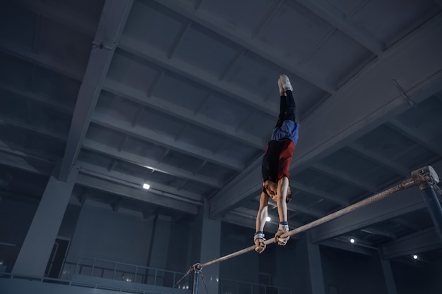 Little male gymnast training in gym flexible and active