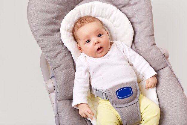 A little newborn girl lies in baby rocking chair