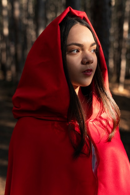 Free photo little red riding hood in the forest portrait