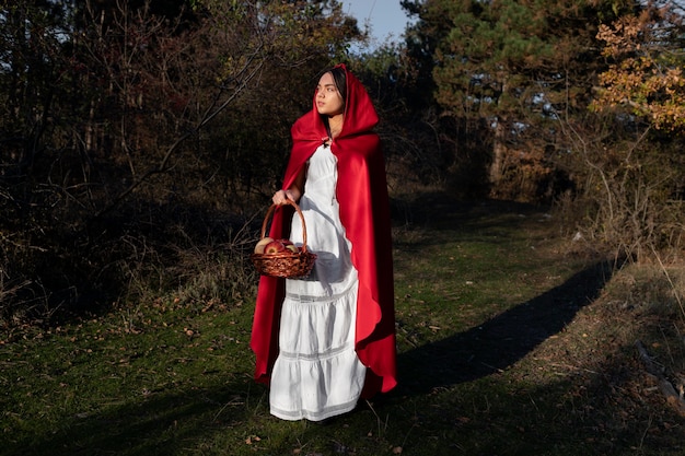 Little red riding hood with wooden basket with goodies