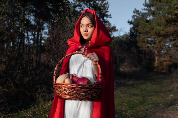 Little red riding hood with wooden basket with goodies