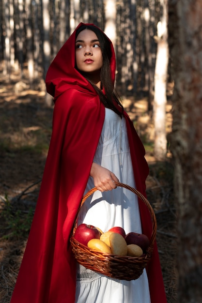 Little red riding hood with wooden basket with goodies