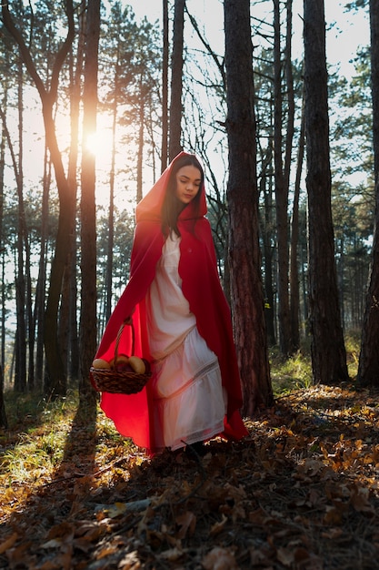 Free photo little red riding hood with wooden basket with goodies