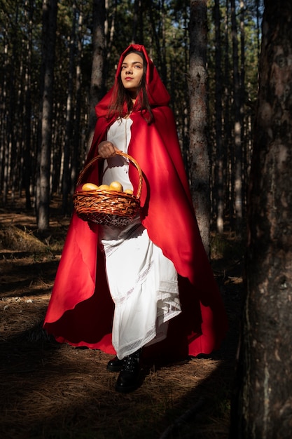 Free Photo little red riding hood with wooden basket with goodies