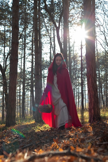 Little red riding hood with wooden basket with goodies