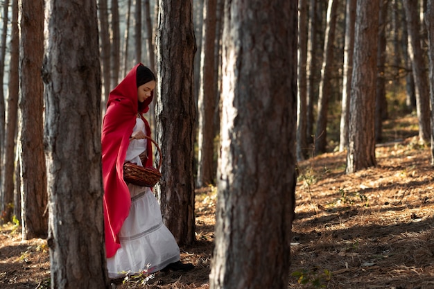 Little red riding hood with wooden basket with goodies