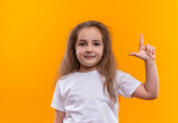 little school girl wearing white t-shirt put up her finger on isolated orange wall