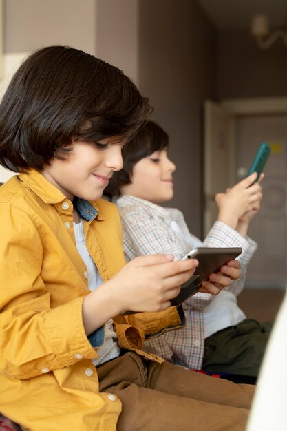 Little twins playing on different devices