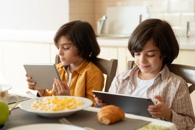 Little twins playing on their tablet