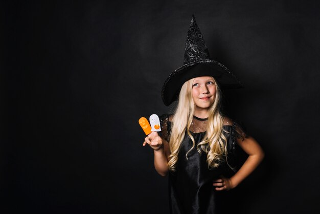 Free Photo little witch gesturing victory and looking away