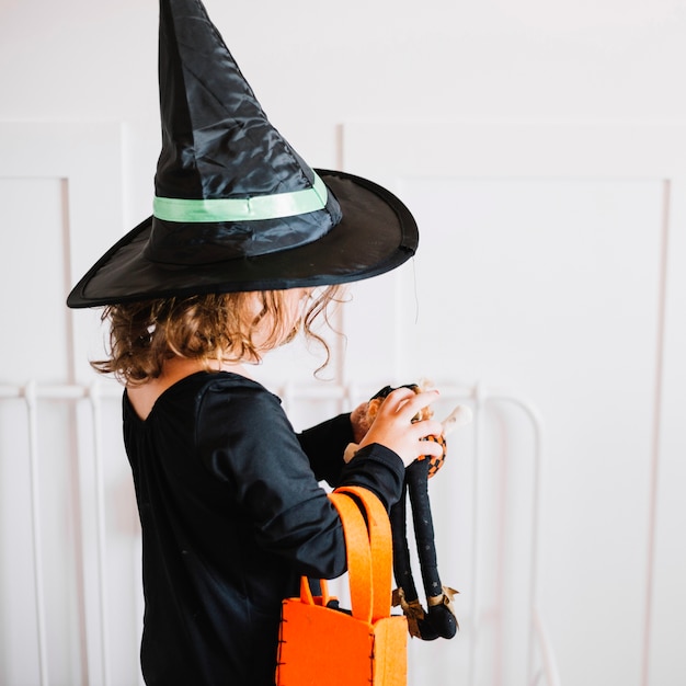 Free photo little witch holding toy